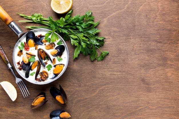 Free photo flat-lay mussels in white sauce and parslet with copyspace