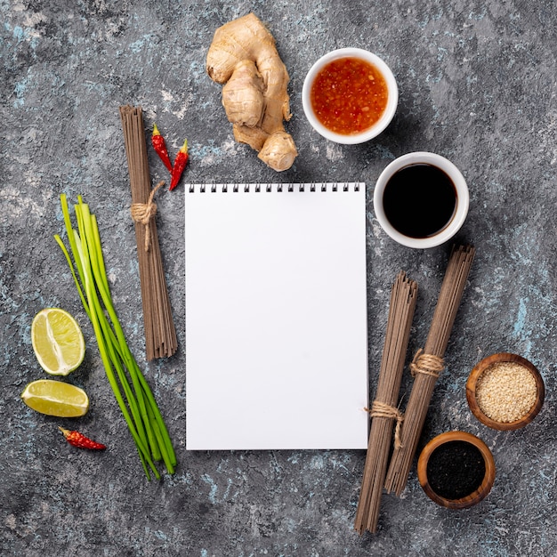 Flat lay noodles and spices with blank notebook