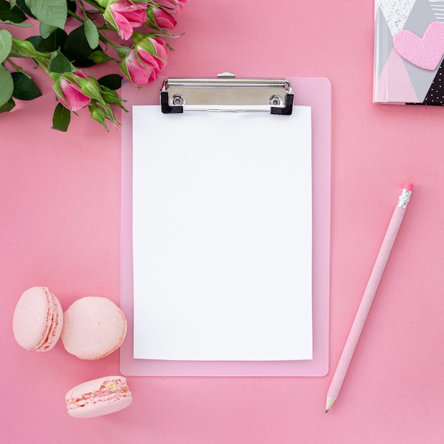 Free photo flat lay of notepad with pen and macarons