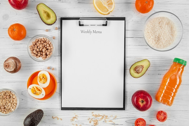 Free Photo flat lay of notepad with vegetables and orange juice bottle