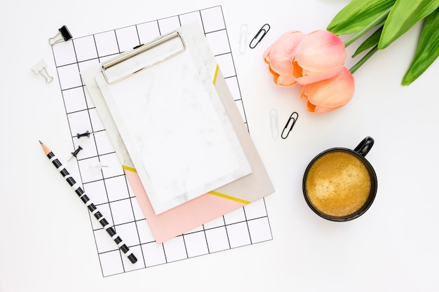 Flat lay of office stationery with coffee and tulips