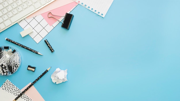 Flat lay of office stationery with keyboard and pencils