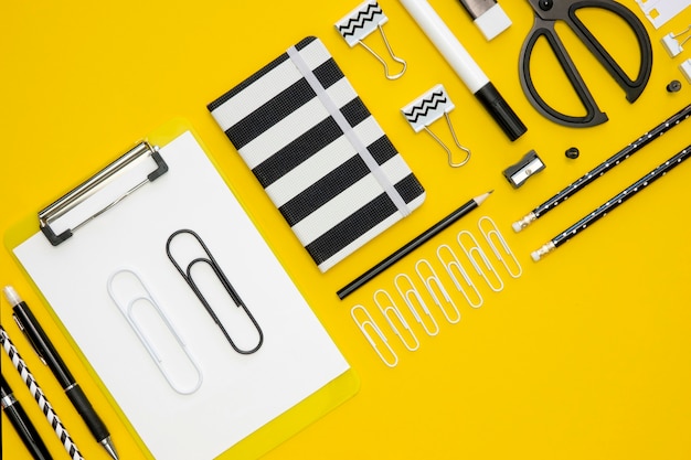 Free Photo flat lay of office stationery with paper clips and notepads