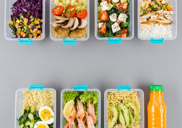 Free photo flat lay of organized plastic food containers with meals