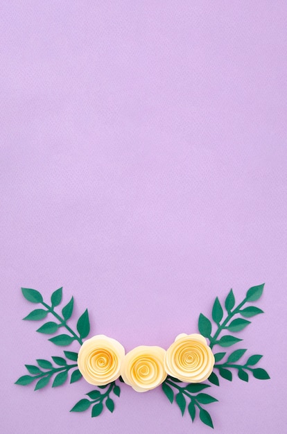 Free photo flat lay paper flowers and leaves on purple background