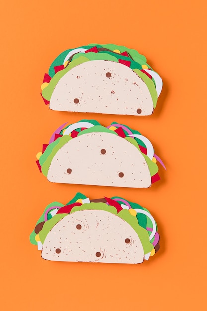 Free photo flat lay paper tacos on orange background