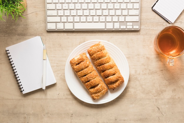 Flat lay pastry on plate with notebook