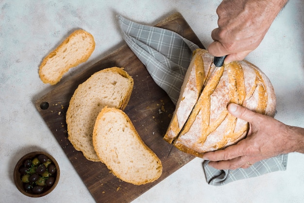 Free photo flat lay person cutting slices of bread