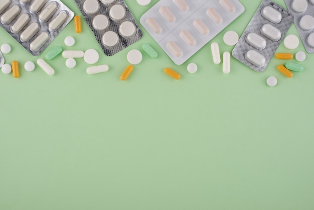 Flat lay pills on green background