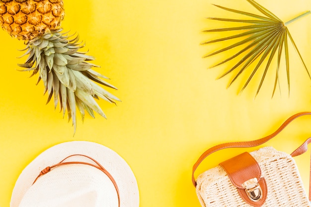 Flat lay of pineapple with summer accessories