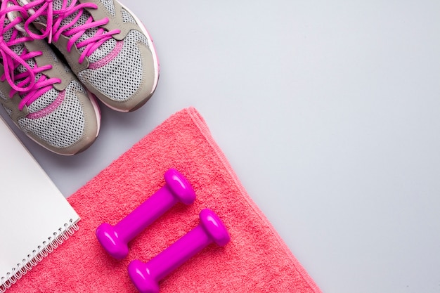 Free photo flat lay pink sports attributes with notebook