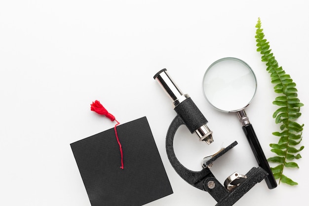 Flat lay plant, microscope and cap