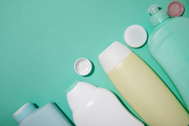 Free Photo flat lay plastic bottles on green background