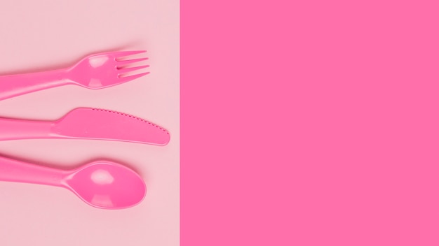 Free photo flat lay of plastic pink cutlery for baby shower