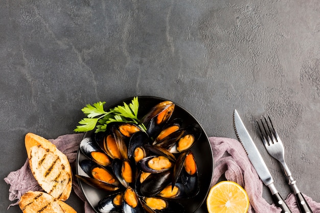 Free photo flat-lay plate of cooked mussels with copy space