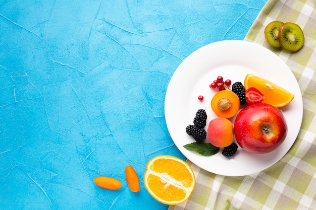 Flat-lay plate of fresh berries and fruits with copyspace