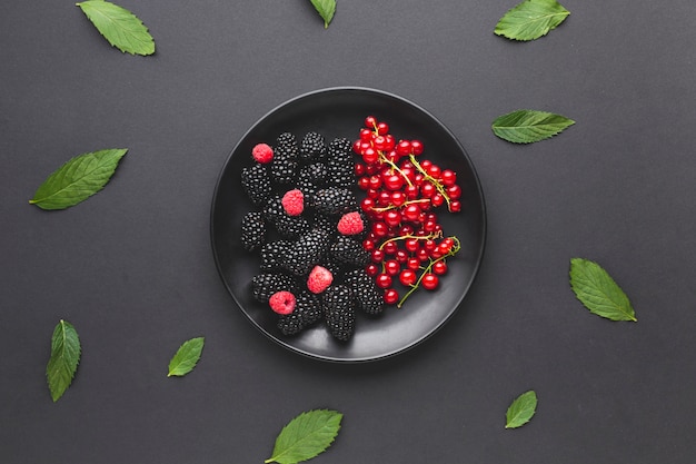 Free Photo flat-lay plate of fresh berries with leaves