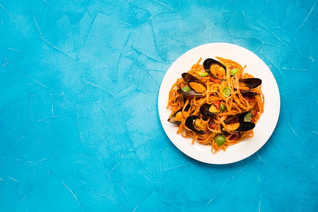 Flat-lay plate of mussel pasta with copyspace