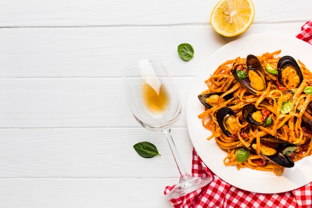 Flat-lay plate of mussels pasta on tablecloth with copyspace