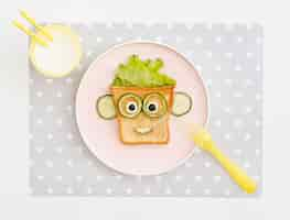 Free photo flat lay plate with toast face shape with apple