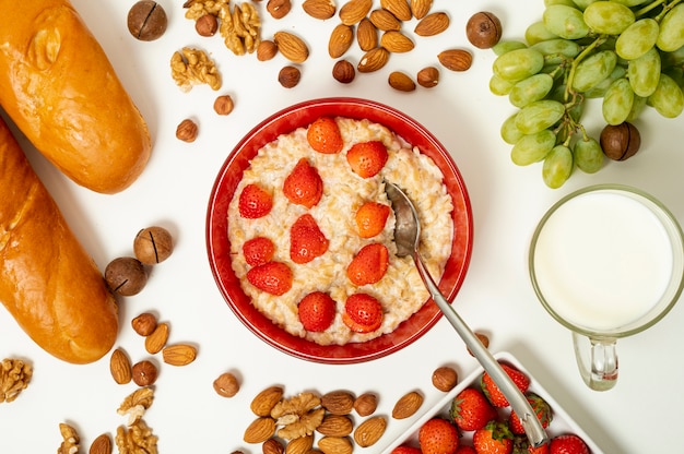 Flat lay porridge with fruits and nuts arrangement on plain background