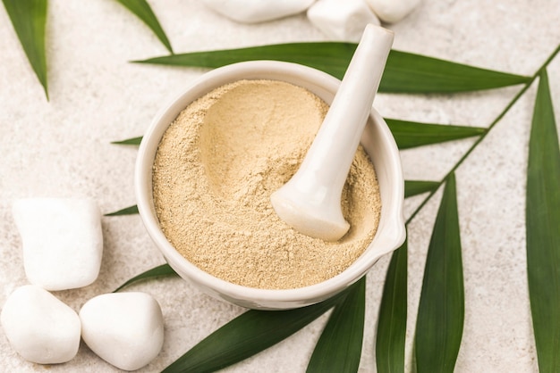 Flat lay of powder in bowl with pestle