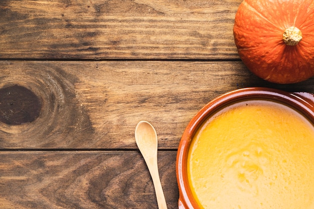 Free Photo flat lay pumpkin with soup and wooden spoon