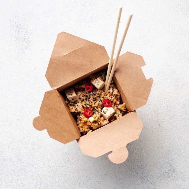 Flat lay rice and vegetables takeaway with chopsticks