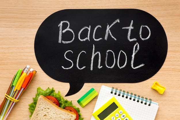 Flat lay of school essentials with sandwich and notebook