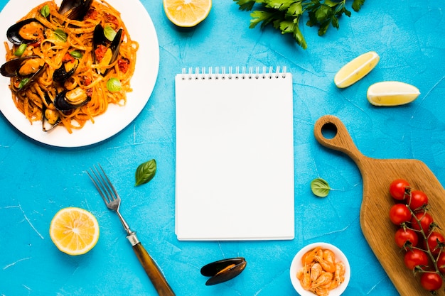 Flat-lay seafood dishes with notebook