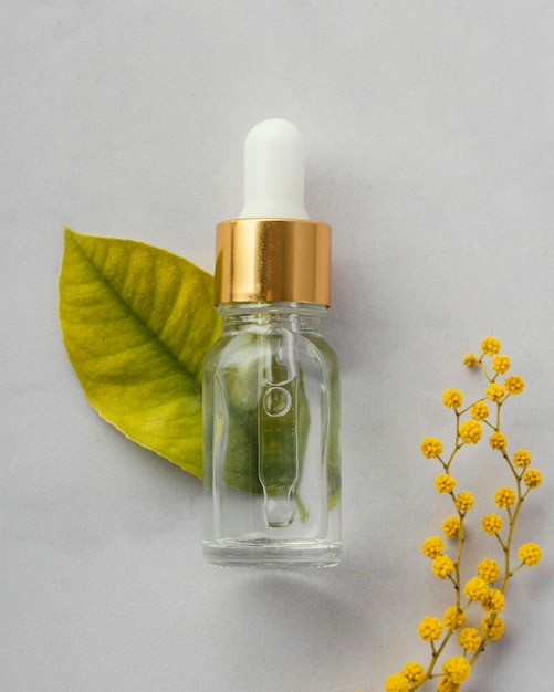 Free Photo flat lay serum bottle and leaf