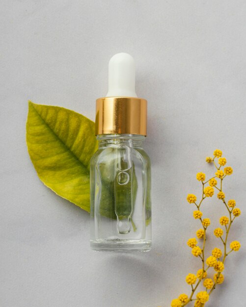 Flat lay serum bottle and leaf