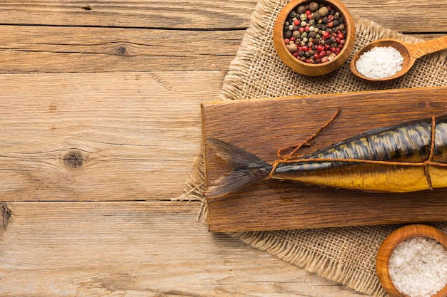 Free Photo flat lay smoked fish on wooden background