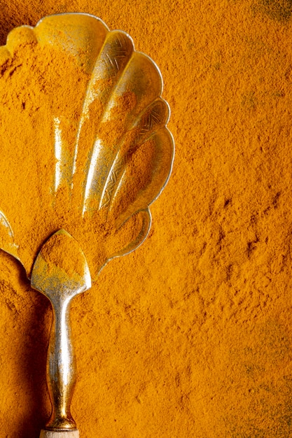 Flat lay of spoon with turmeric with copy space