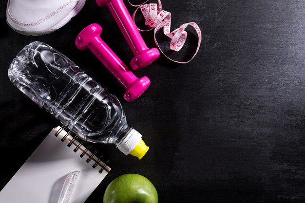 Flat Lay Sport Concept Healthy Life Equipment on Dark Vibrant Background. Closeup with Copy Space. 