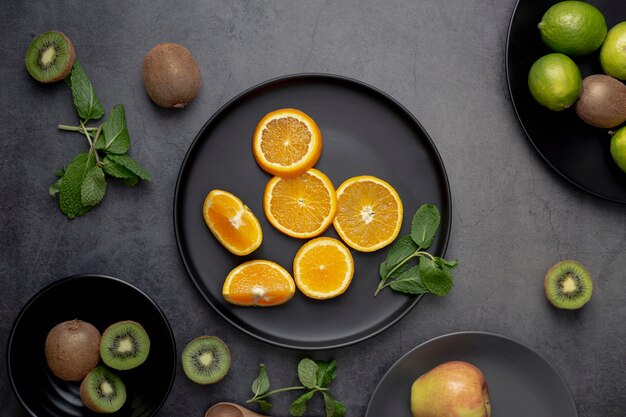 Flat lay of tangerine slices on plate with kiwi