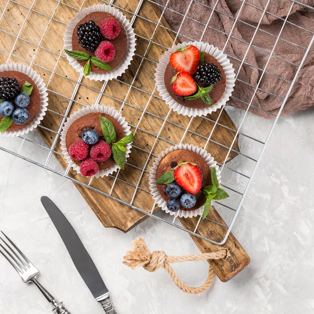 Free photo flat lay tasty muffin with forest fruit and cutlery