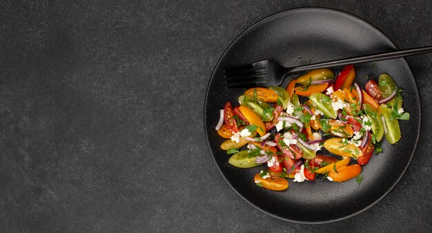 Flat lay tomato mix salad with feta cheese, rucola and copy-space