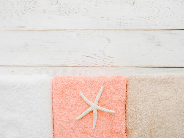 Free Photo flat lay towels on wooden background with copy space