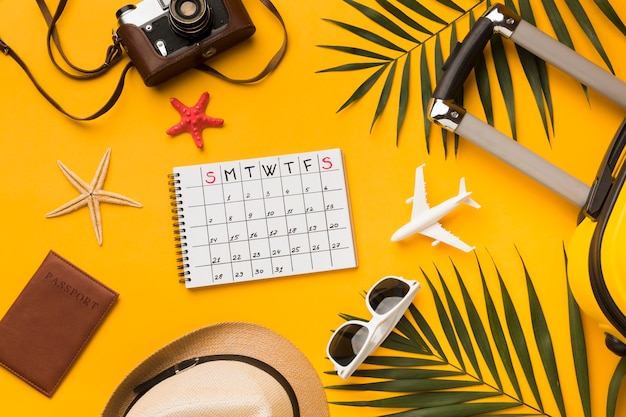 Free photo flat lay of travel essentials with calendar and sunglasses