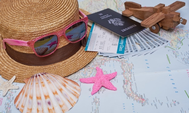 Flat lay traveler accessories  with palm leaf, camera, hat, passports, money, air tickets, airplanes, map, and sunglasses. Top view, travel or vacation concept.