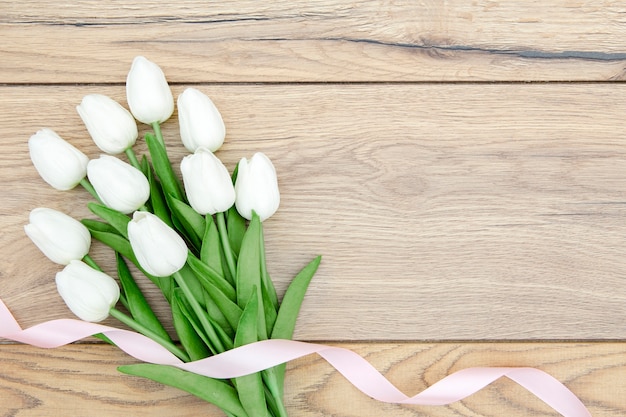 Flat lay of tulips bouquet on wooden table