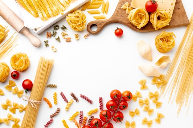 Flat lay uncooked pasta mix with tomatoes and hard cheese