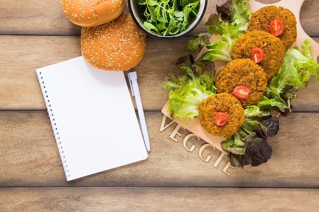 Flat lay vegan dishes next to notebook mock-up