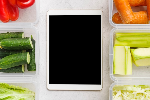 Free photo flat lay of vegetables and tablet