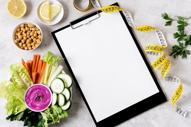 Flat lay of vegetables with chickpeas and notebook