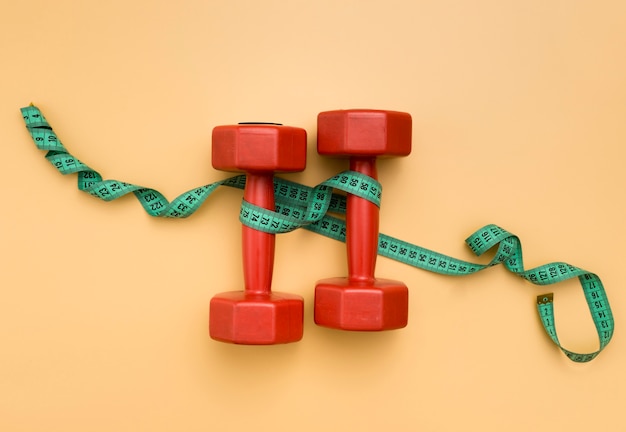 Free Photo flat lay of weights with measuring tape around them