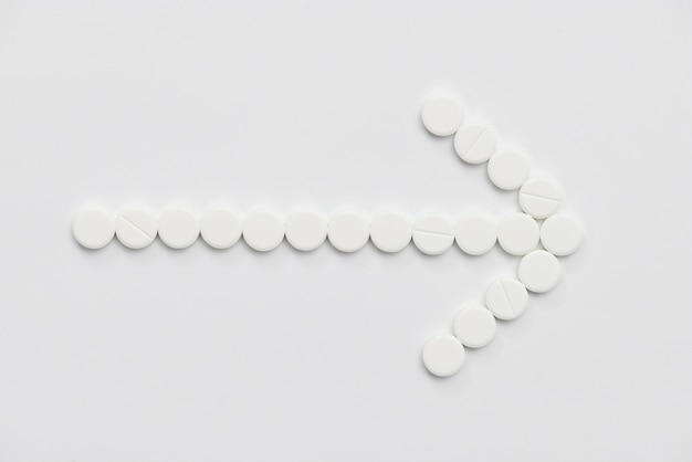 Free Photo flat lay white pills arrow