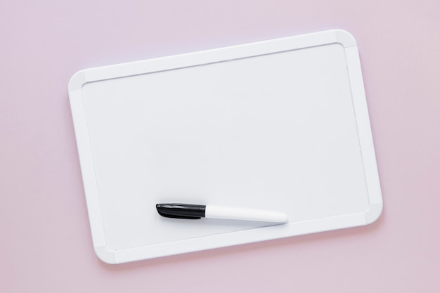 Free photo flat lay whiteboard with marker on top