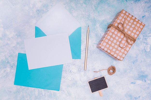 Free photo flat lay with blue envelope and birthday invitation mock up